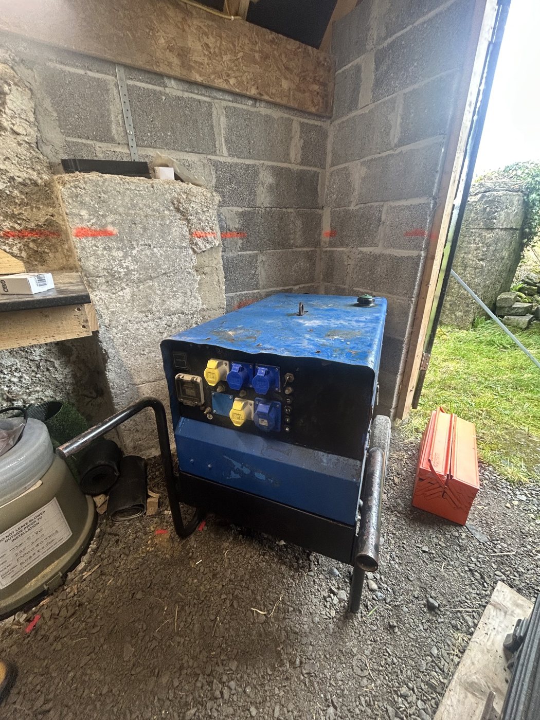 A generator set up in a block-built shed