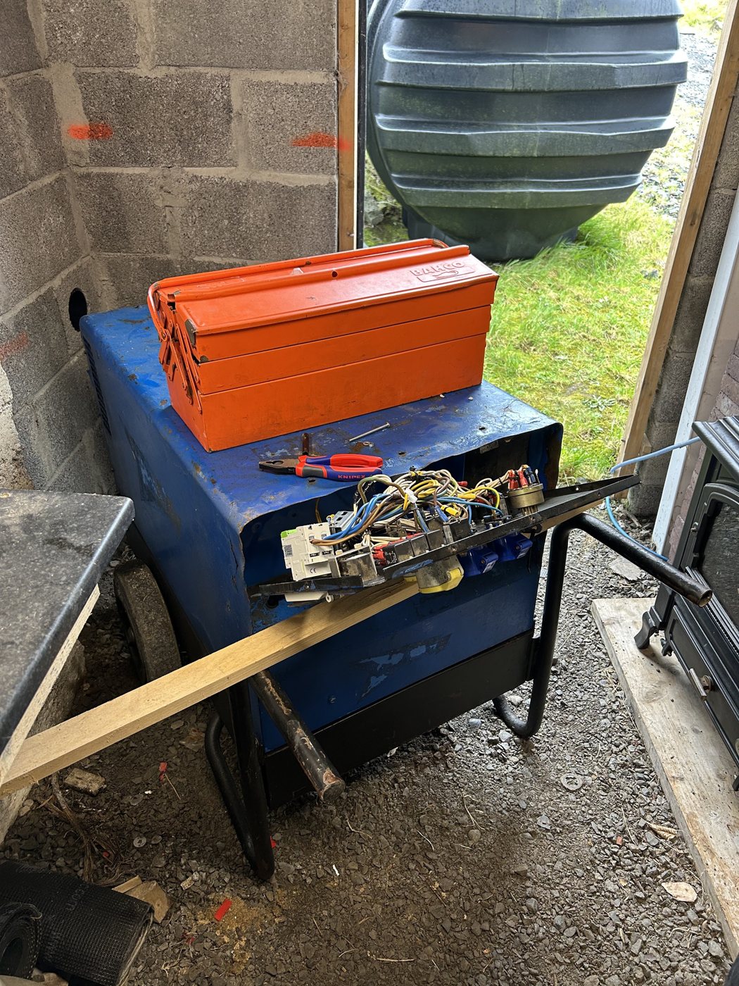 A generator with a toolbox and cabling resting on it
